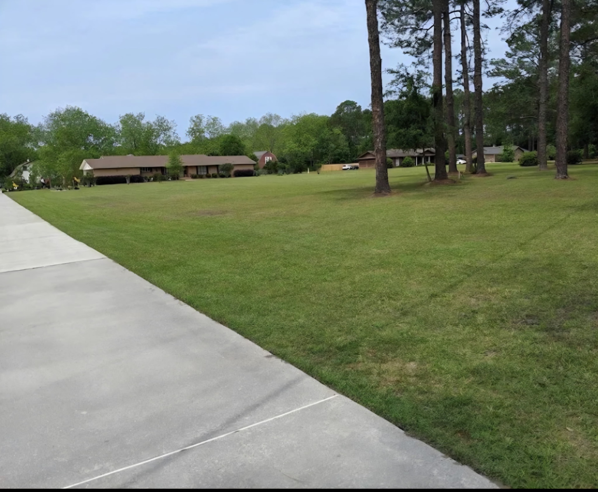 Wide manicured residential lawn along driveway