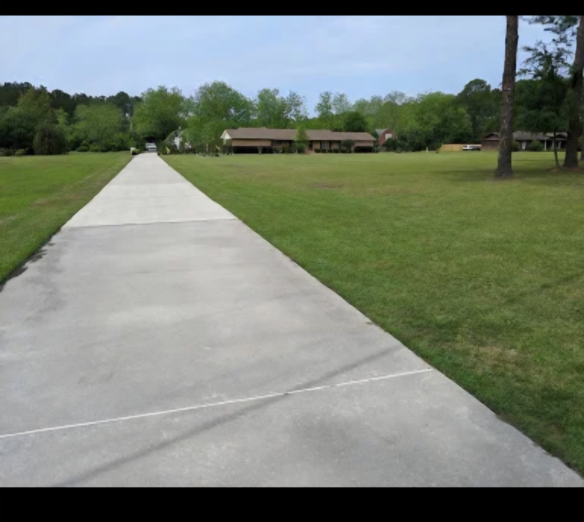 Manicured residential lawn with long driveway in Moultrie