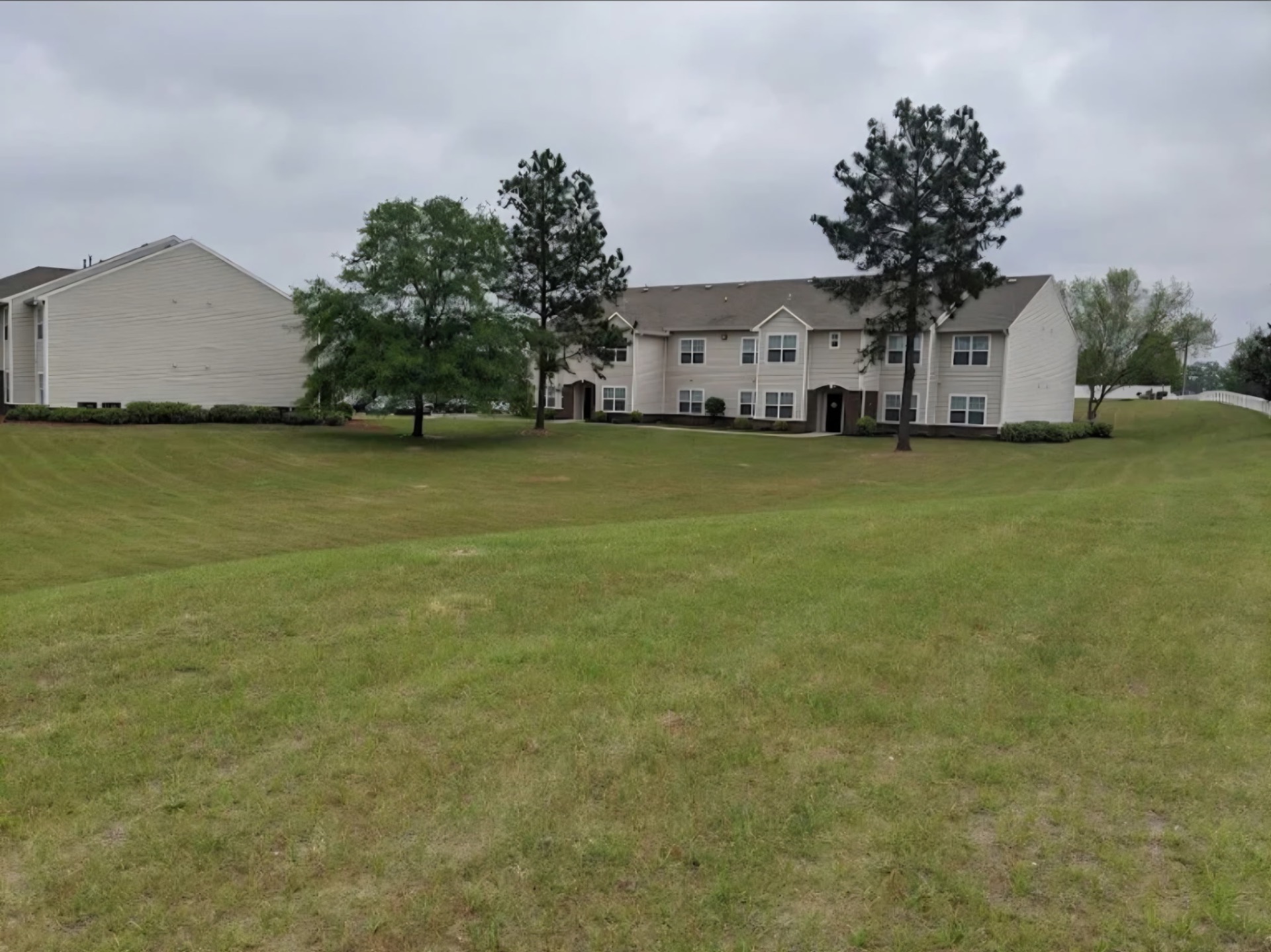 Freshly mowed apartment community lawn with mature trees